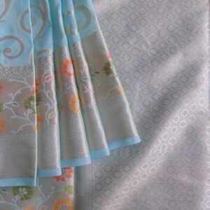 Georgette Saree in Light Blue shade with Silver zari weaves in the famous Banarasi Jaal work. Border has Banarasi floral motifs with Meena work.