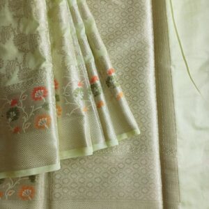 Georgette Saree in Light Green shade with Silver zari weaves in the famous Banarasi Jaal work. Border has Banarasi floral motifs with Meena work.