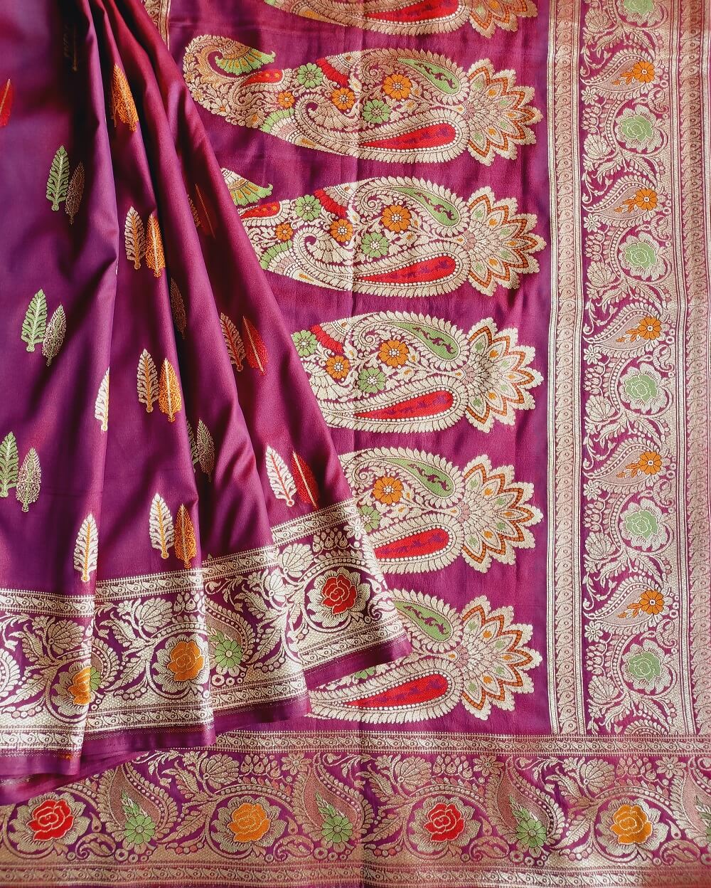Katan Silk Saree in Rich wine shade with small tree motifs in son rupa or gold and silver weaves all over the body. Meenakari work has been done all over saree.