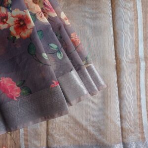Organza saree in Dark Grey shade. Digital floral prints all over the saree with a Banarasi border. Simple tissue pallu i.e. thin zari stripes on pallu.