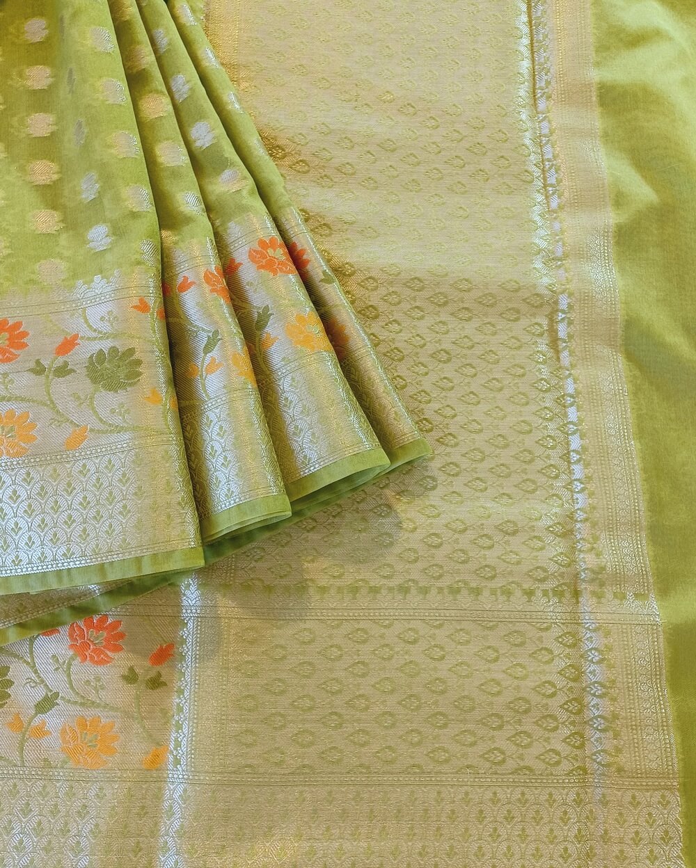 Georgette Saree in Mehandi Green Shade with Silver zari weaves in Butta work. Border has Banarasi floral motifs with Meena work. Pallu have Silver zari work.