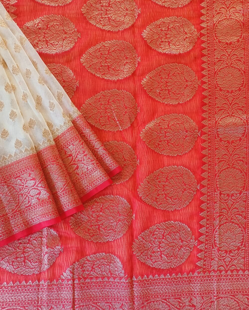 Georgette Saree in Pearl White with Red combination, Khaddi Border with Gold zari weaves in the famous Banarasi floral buttis work all over the saree.