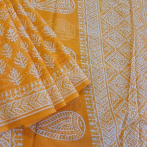 Pure Mulmul Cotton Saree in Mango Yellow. This soft cotton saree has been completely hand block printed with Bagru prints in floral motifs with natural dyes.