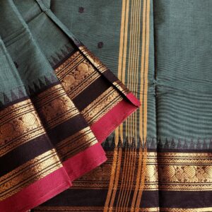Handloom Pure Kanchi Cotton Saree in Dark Teal with Black Border and bright pink selvedge, it has Small Buttas all over Saree with Zari Border and Simple Pallu with Stripes. It has Big Border with traditional Peacock and Fish Motifs, Border is woven with zari.