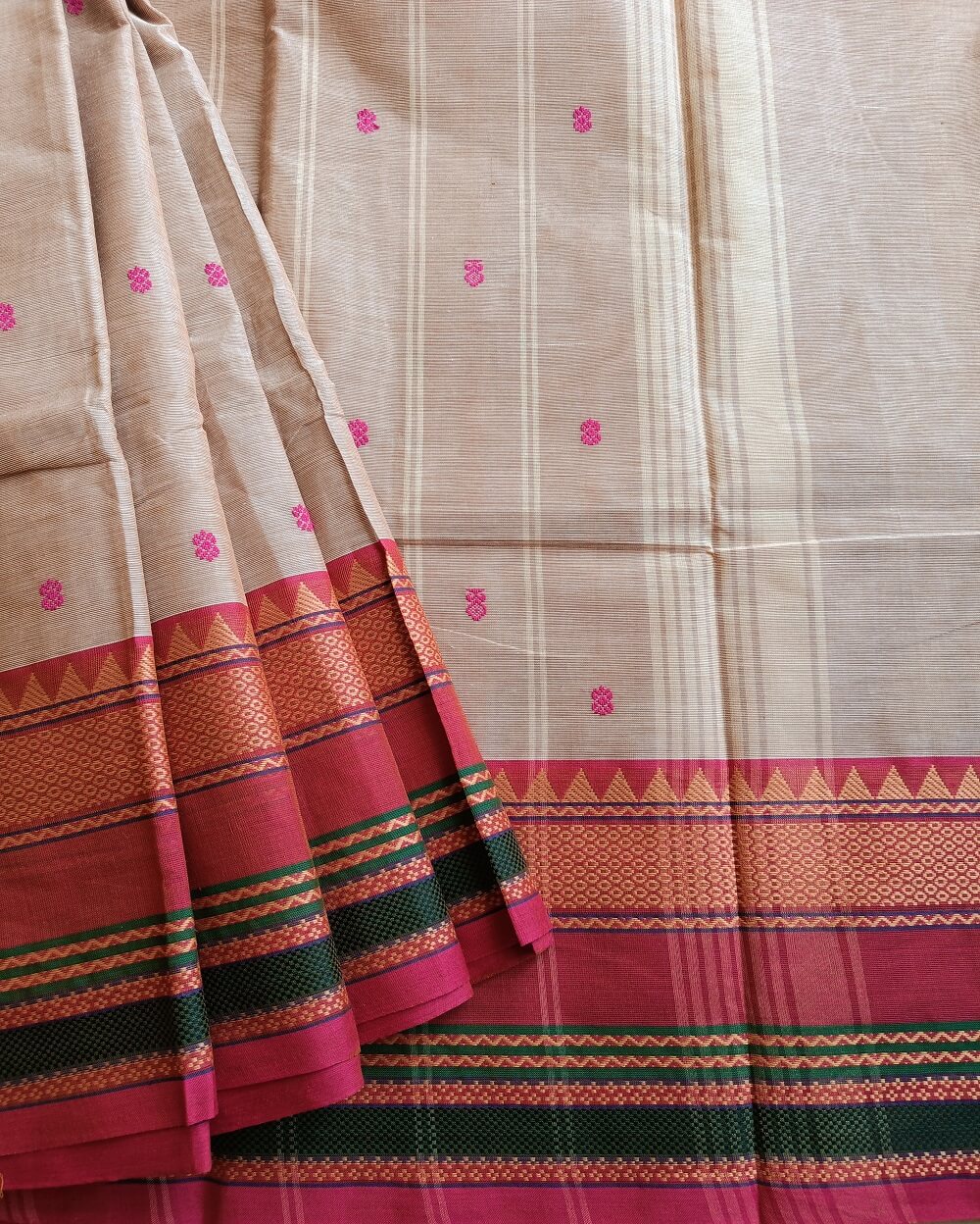 Handloom Pure Kanchi Cotton Saree in Beige Shade with Pink border, the saree Small buttas over saree with big thread border in Traditional motifs. Simple Pallu with stripes.