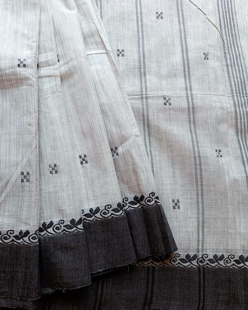 Handloom Pure Kanchi Cotton Saree in Whiteish Grey shade with Charcoal Black border, it has Buttas on Saree with contemporary motifs small Thread Border.
