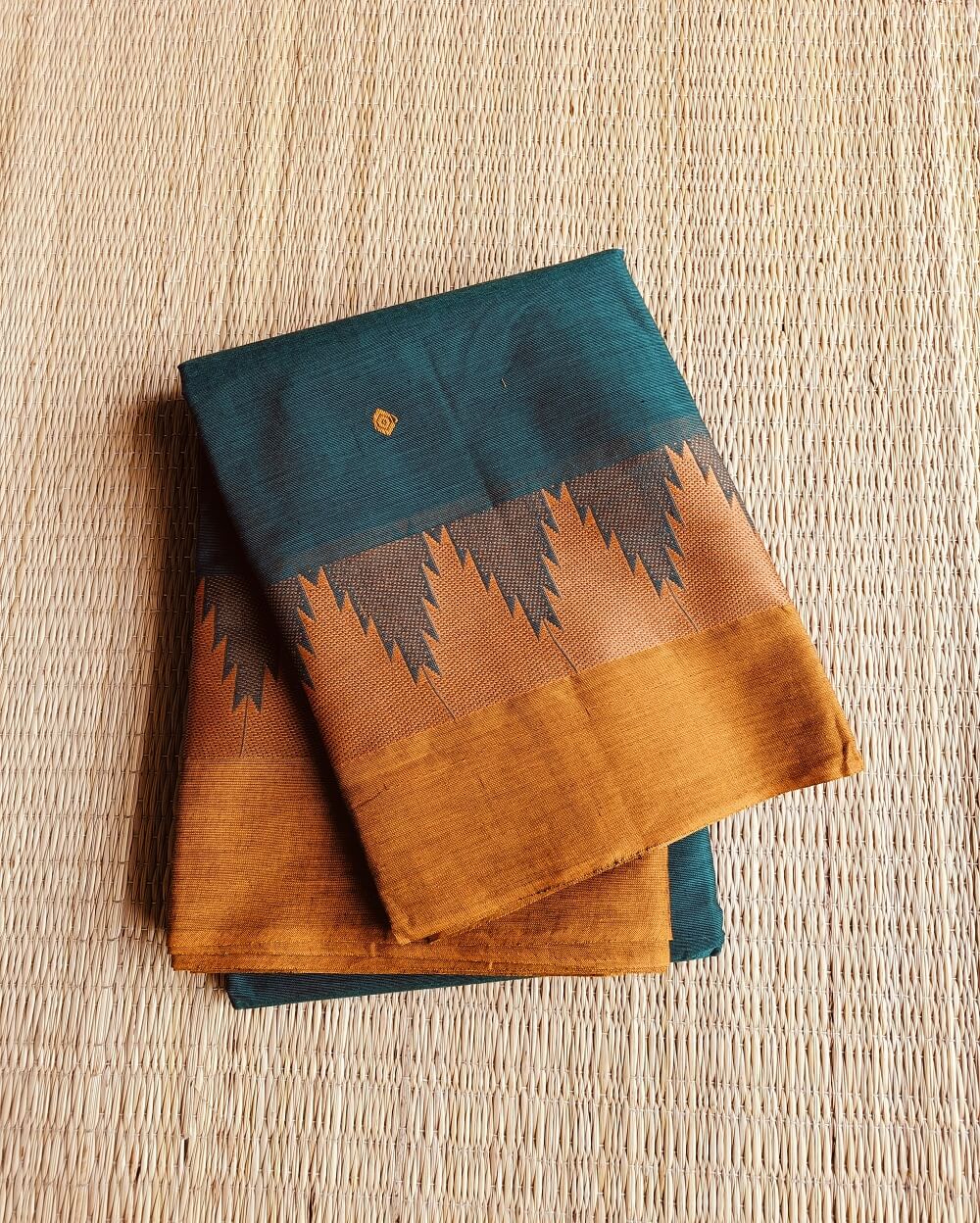 Handloom Kanchi Cotton Saree in Sea Green shade with Yellow border, it has Buttas on Saree and Thread Border with traditional gopuram or temple motifs. These sharp towers like motifs are also known as Thazhampoo motifs.