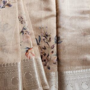 Tussar silk saree in Natural Tussar shade with floral digital prints, it has a very elegant silver border with small motifs. A very contemporary earthy shade with subtle shine and classic prints. Saree comes with a blouse piece in small prints.