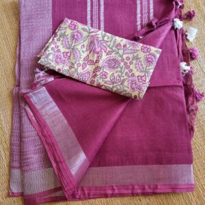 Dark Pink linen saree with silver tissue zari border and a light yellow handcrafted - hand block printed mul mul cotton blouse piece, The Linen saree comes comes with a plain body in very soothing shade with a subtle silver tissue zari border. The pallu is simple with silver stripes. The blouse piece is running blouse piece that comes along with saree and the additional one is a beautiful hand block printed