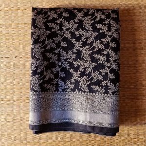 Banarasi Cotton Saree in Black colour with Cream resham threads woven all over. It has traditional Banarasi floral motifs in jaal weaves which is a very famous traditional weave where the motifs are interconnected throughout the saree.