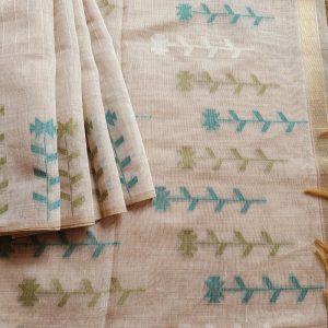 Chanderi Saree silk cotton in Light Beige with green Jamdani motifs woven all over. Saree comes with a blouse piece in small buttis. Blouse is in contrast shade that matches with the buttis and borders, Pallu has beautiful floral weaves in jamdani pattern.