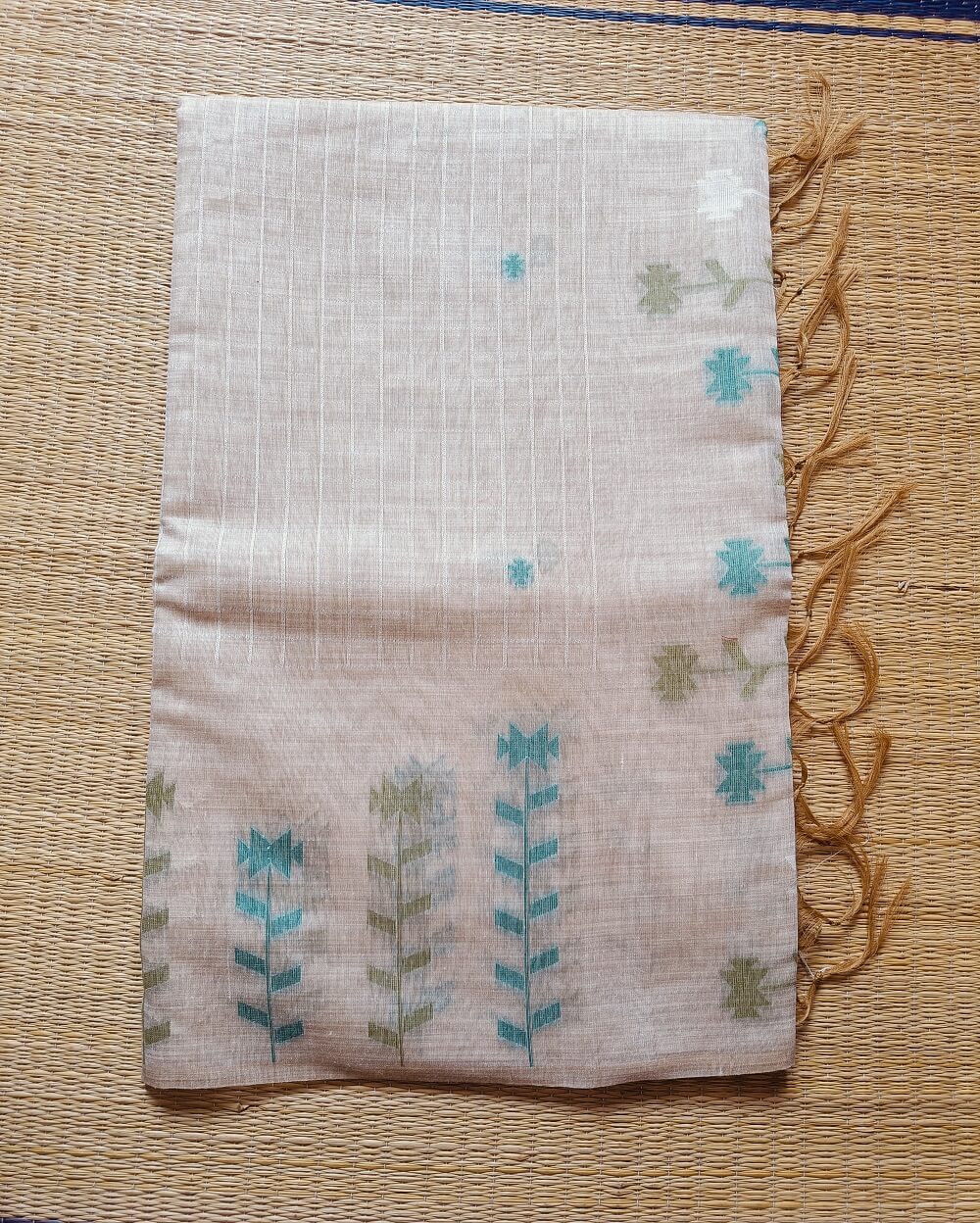 Chanderi Saree silk cotton in Light Beige with green Jamdani motifs woven all over. Saree comes with a blouse piece in small buttis. Blouse is in contrast shade that matches with the buttis and borders, Pallu has beautiful floral weaves in jamdani pattern.