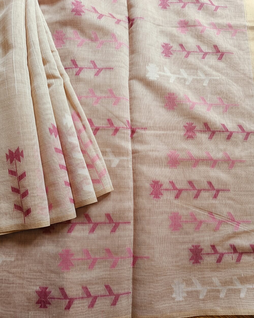 Chanderi Saree silk cotton in Light Beige with pink Jamdani motifs woven all over. Saree comes with a blouse piece in small buttis. Blouse is in contrast shade that matches with the buttis and borders, Pallu has beautiful floral weaves in jamdani pattern.
