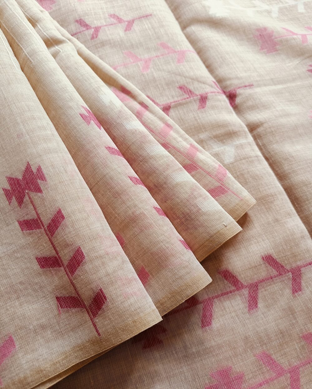 Chanderi Saree silk cotton in Light Beige with pink Jamdani motifs woven all over. Saree comes with a blouse piece in small buttis. Blouse is in contrast shade that matches with the buttis and borders, Pallu has beautiful floral weaves in jamdani pattern.