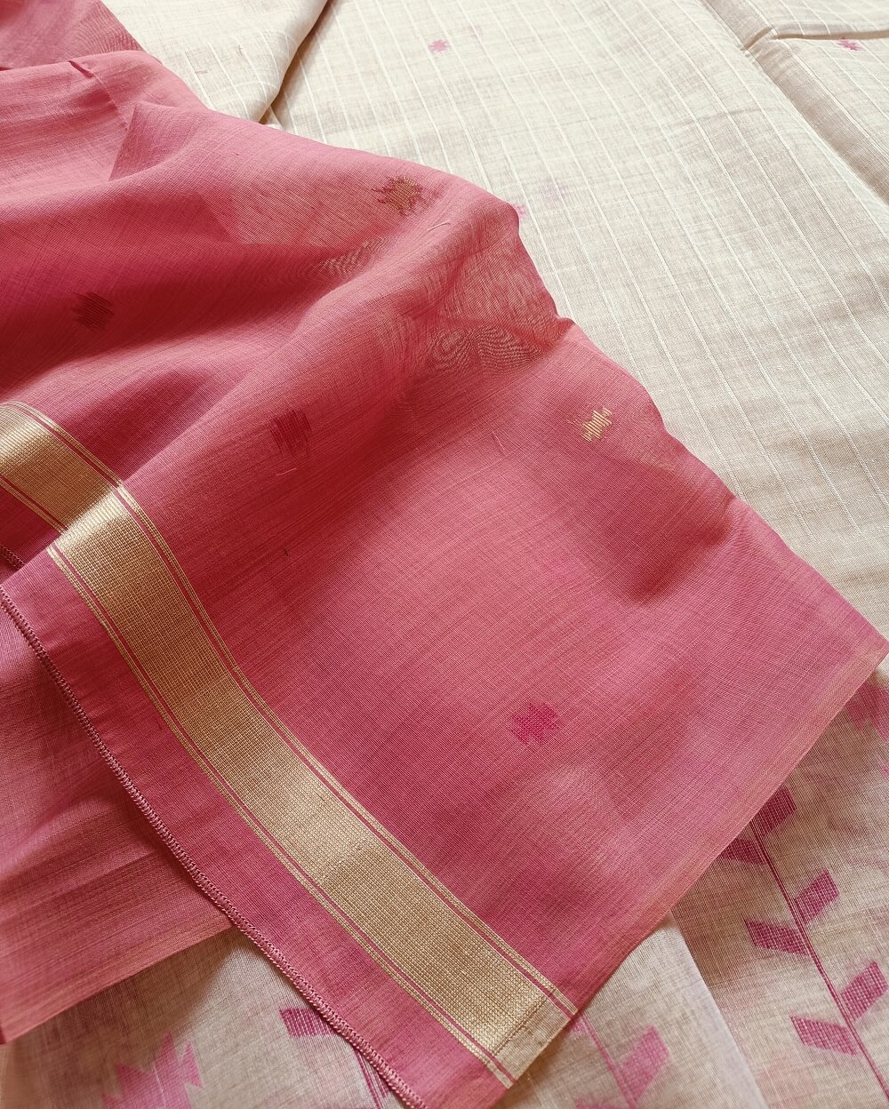 Chanderi Saree silk cotton in Light Beige with pink Jamdani motifs woven all over. Saree comes with a blouse piece in small buttis. Blouse is in contrast shade that matches with the buttis and borders, Pallu has beautiful floral weaves in jamdani pattern.
