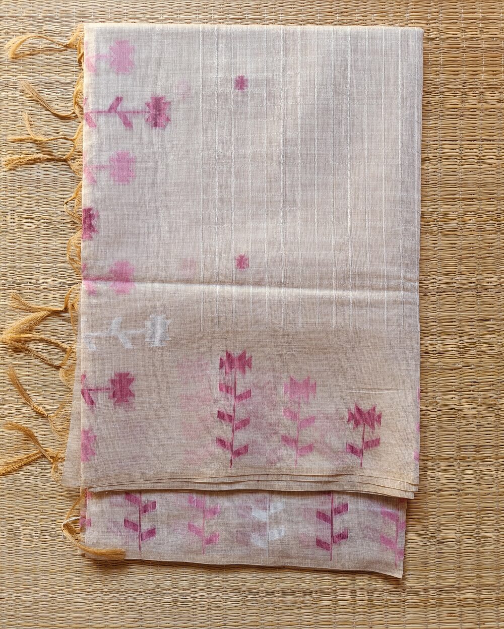 Chanderi Saree silk cotton in Light Beige with pink Jamdani motifs woven all over. Saree comes with a blouse piece in small buttis. Blouse is in contrast shade that matches with the buttis and borders, Pallu has beautiful floral weaves in jamdani pattern.