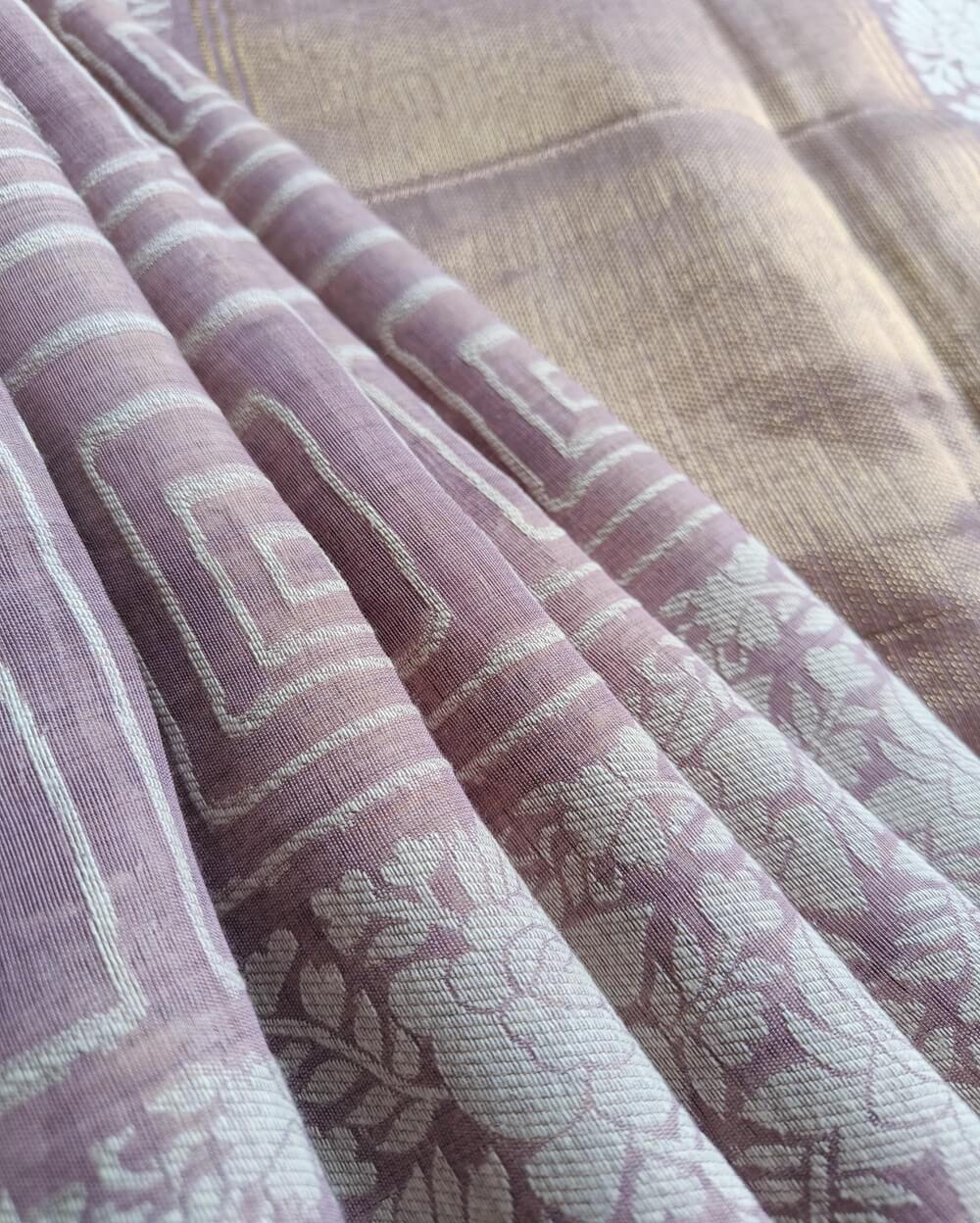 Light Lavender Linen saree with Mul Mul cotton fabric .This Linen saree has thread woven geometric square patterns all over the saree. The pallu is simple with a small line of zari woven . It's has beautiful floral border that compliments the over all unique look of the saree. The designs are very contemporary and exclusive.
