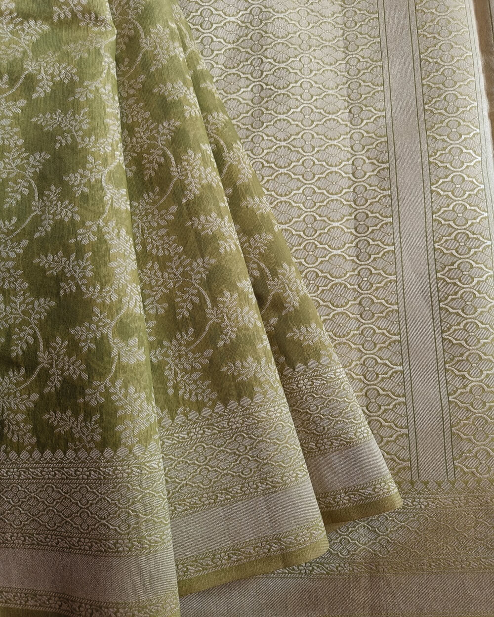 Banarasi Cotton Saree in Light Green colour with Cream resham threads woven all over. It has traditional Banarasi floral motifs in jaal weaves which is a very famous traditional weave where the motifs are interconnected throughout the saree.