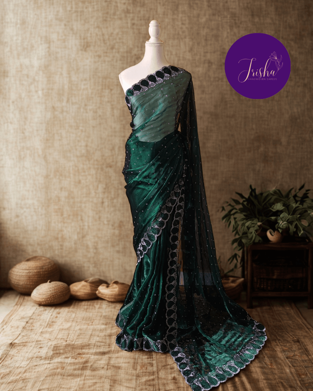 Jimmy Choo Organza silk saree in Emerald Green shade with black and white Swarovski crystal work in the border. The saree has Swarovski work on the shoulder part and the skirt portion of the saree in the form of small buttas. The Pallu is beautifully done in a C shape work pattern.