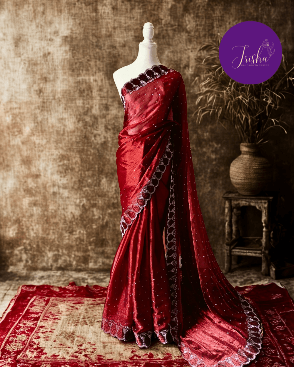 Jimmy Choo Organza silk saree in Maroon shade with black and white Swarovski crystal work in the border. The saree has Swarovski work on the shoulder part and the skirt portion of the saree in the form of small buttas. The Pallu is beautifully done in a C shape work pattern.