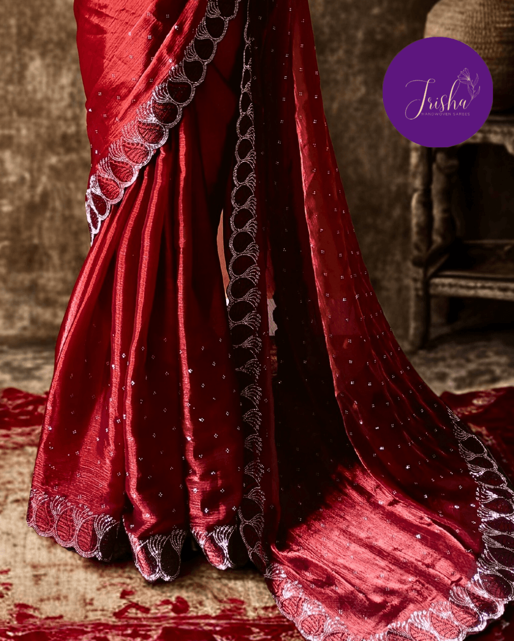 Jimmy Choo Organza silk saree in Maroon shade with black and white Swarovski crystal work in the border. The saree has Swarovski work on the shoulder part and the skirt portion of the saree in the form of small buttas. The Pallu is beautifully done in a C shape work pattern.