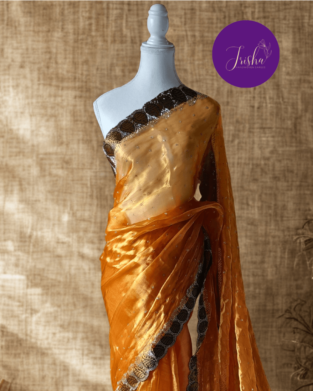 Jimmy Choo Organza silk saree in Yellow shade with black and white Swarovski crystal work in the border. The saree has Swarovski work on the shoulder part and the skirt portion of the saree in the form of small buttas. The Pallu is beautifully done in a C shape work pattern.