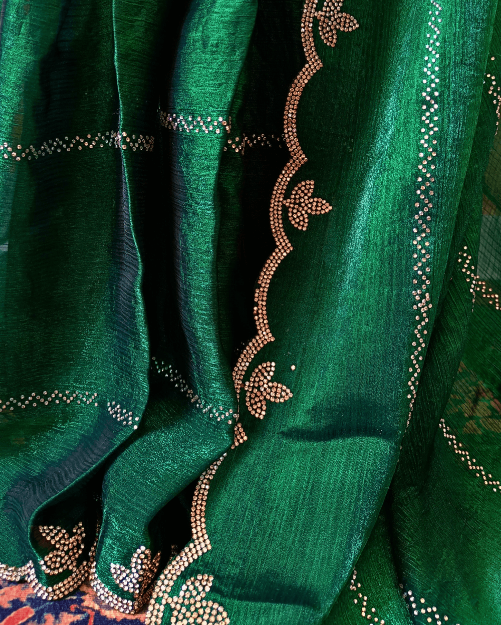 Emerald Green fendy silk saree with Swarovski crystal work all over the shoulder and pallu portion in stripes pattern. Border throughout the saree and Pallu has diamond stone work .The saree in the skirt portion has 2 lines of striped Swarovski crystal work. The Pallu is beautifully done in a C shape work pattern. The shade has a light dual tone effect. Blouse piece has back design in Swarovski crystal work and sleeves potion has diamond stone work done.