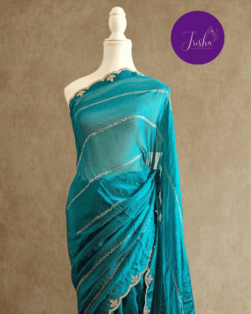 Peacock Blue fendy silk saree with Swarovski crystal work all over the shoulder and pallu portion in stripes pattern. Border throughout the saree and Pallu has diamond stone work .The saree in the skirt portion has 2 lines of striped Swarovski crystal work. The Pallu is beautifully done in a C shape work pattern. The shade has a light dual tone effect. Blouse piece has back design in Swarovski crystal work and sleeves potion has diamond stone work done.
