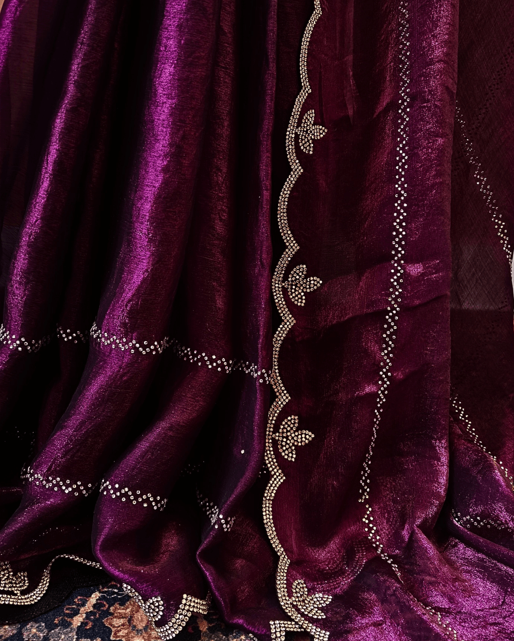 Purple fendy silk saree with Swarovski crystal work all over the shoulder and pallu portion in stripes pattern. Border throughout the saree and Pallu has diamond stone work .The saree in the skirt portion has 2 lines of striped Swarovski crystal work. The Pallu is beautifully done in a C shape work pattern. The shade has a light dual tone effect. Blouse piece has back design in Swarovski crystal work and sleeves potion has diamond stone work done.