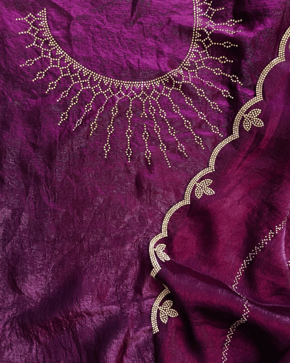 Purple fendy silk saree with Swarovski crystal work all over the shoulder and pallu portion in stripes pattern. Border throughout the saree and Pallu has diamond stone work .The saree in the skirt portion has 2 lines of striped Swarovski crystal work. The Pallu is beautifully done in a C shape work pattern. The shade has a light dual tone effect. Blouse piece has back design in Swarovski crystal work and sleeves potion has diamond stone work done.