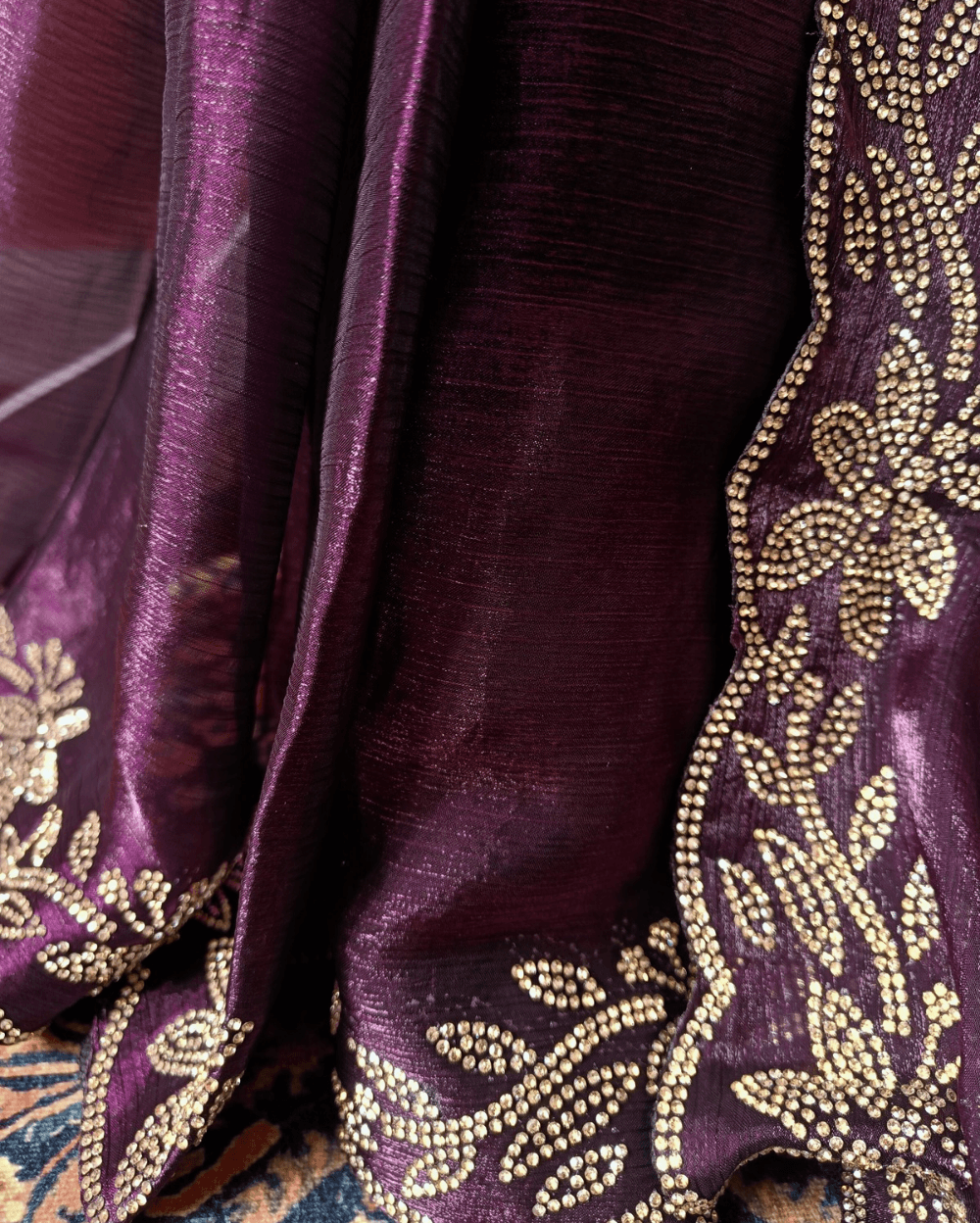 Wine Purple fendy silk saree with Jharkhan Diamond Stone crystal work in Border throughout the saree and Pallu .The Pallu is beautifully done in a C shape work pattern. The shade has a light dual tone effect. Blouse has back design in Swarovski crystal work and sleeves potion has diamond stone work done.