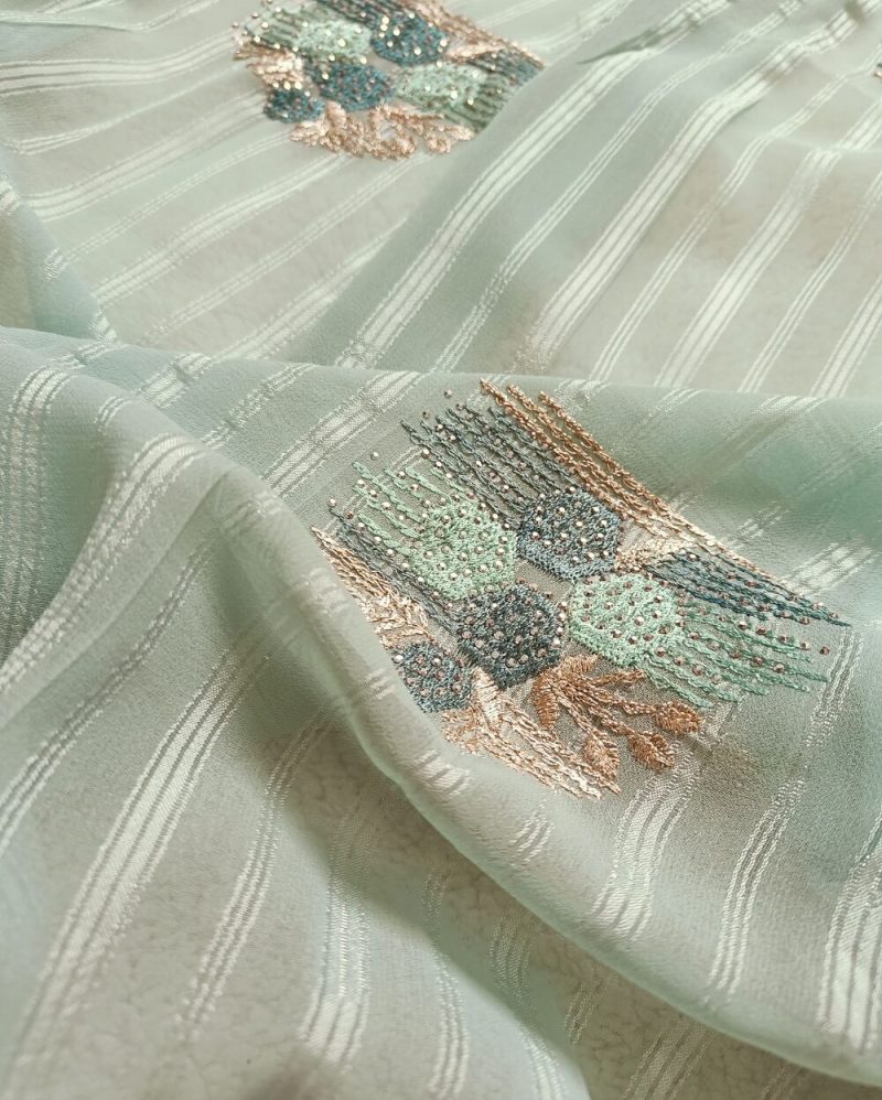 Light weight fancy Georgette Saree in Light Blue shade with Swarovski crystal work all over the shoulder and pallu portion along with embroidery floral work pattern. Border throughout the saree and Pallu has Swarovski work .The saree in the skirt portion has embroidery patterns with Swarovski crystal work. The Pallu is beautifully done in a C shape work pattern.