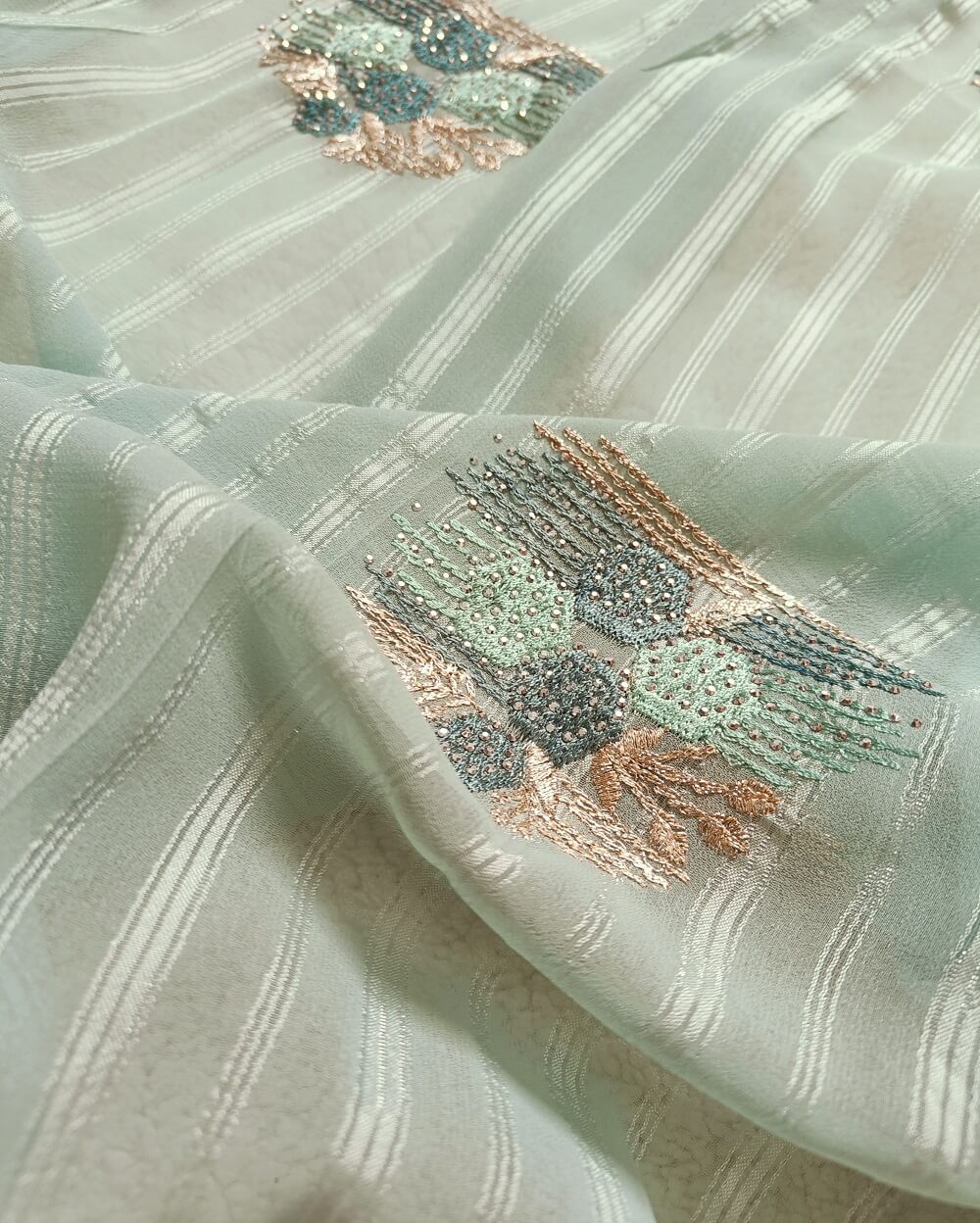 Light weight fancy Georgette Saree in Light Blue shade with Swarovski crystal work all over the shoulder and pallu portion along with embroidery floral work pattern. Border throughout the saree and Pallu has Swarovski work .The saree in the skirt portion has embroidery patterns with Swarovski crystal work. The Pallu is beautifully done in a C shape work pattern.
