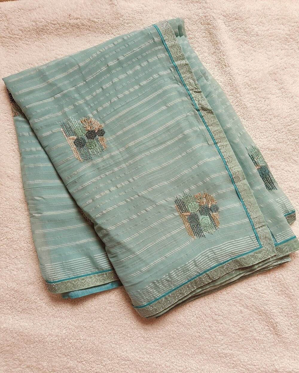 Light weight fancy Georgette Saree in Light Blue shade with Swarovski crystal work all over the shoulder and pallu portion along with embroidery floral work pattern. Border throughout the saree and Pallu has Swarovski work .The saree in the skirt portion has embroidery patterns with Swarovski crystal work. The Pallu is beautifully done in a C shape work pattern.