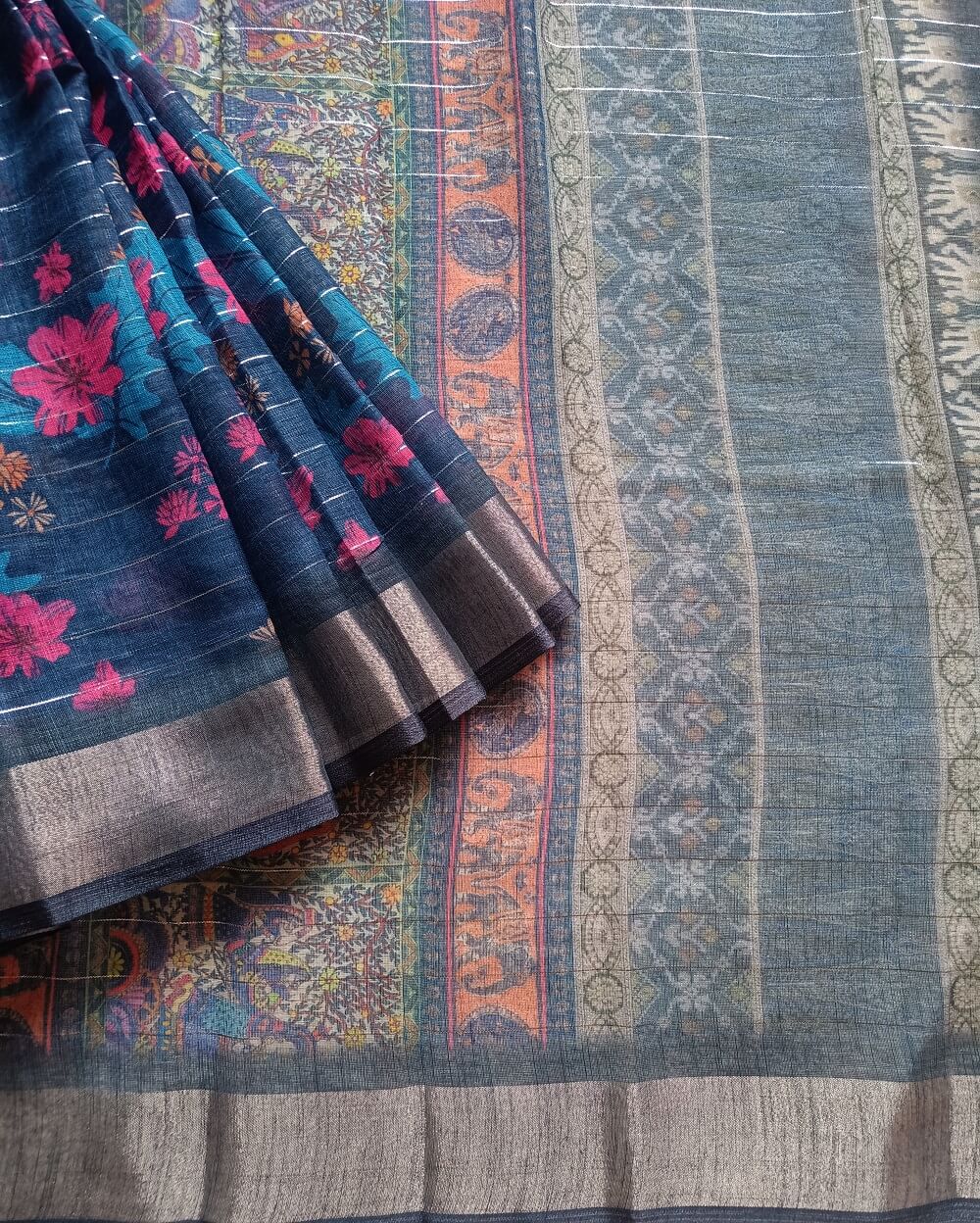 Dark Blue shade Semi Linen saree with silver tissue zari border, this saree comes with digital prints all over the saree with a subtle silver tissue zari border. The pallu is simple with prints.