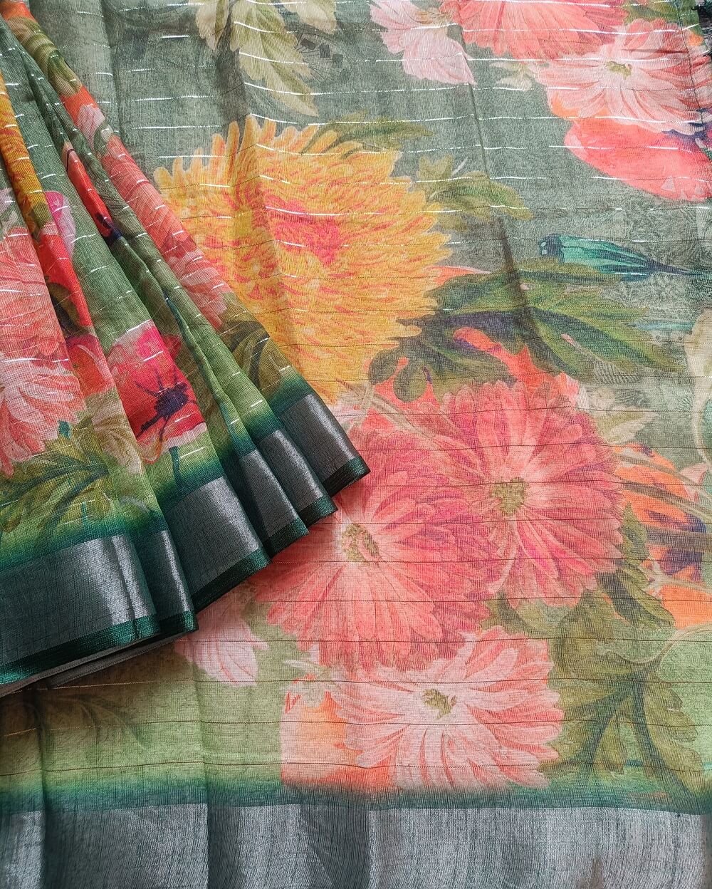 Dark Green shade Semi Linen saree with silver tissue zari border, this saree comes with digital prints all over with a subtle silver tissue zari border. The pallu is simple with prints.