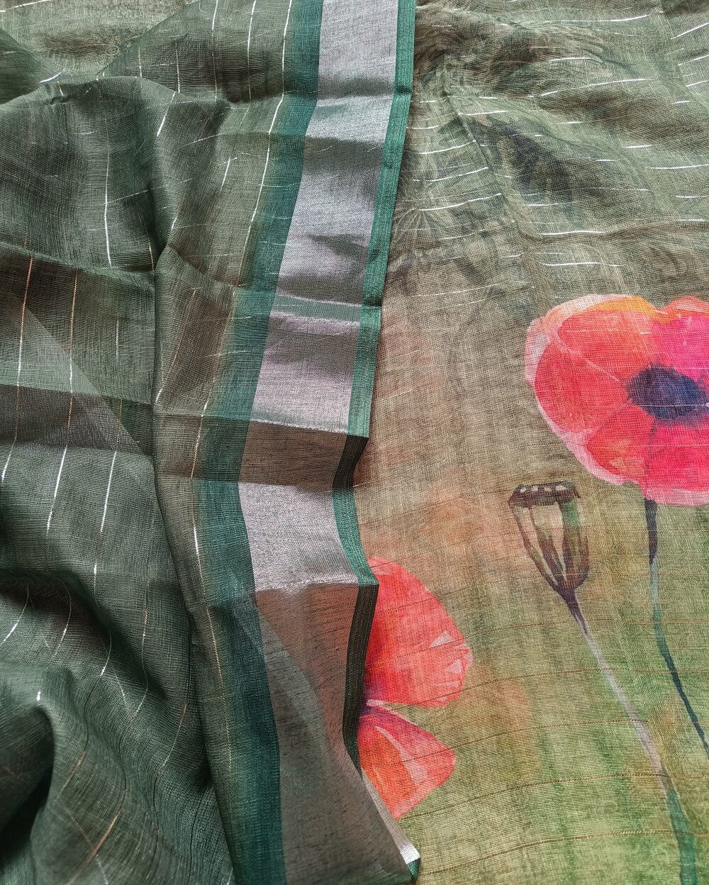 Dark Green shade Semi Linen saree with silver tissue zari border, this saree comes with digital prints all over with a subtle silver tissue zari border. The pallu is simple with prints.