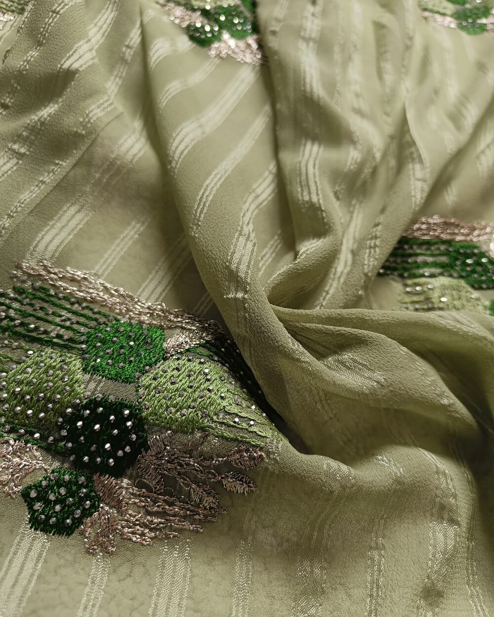 Light weight fancy Georgette Saree in Light Green shade with Swarovski crystal work all over the shoulder and pallu portion along with embroidery floral work pattern. Border throughout the saree and Pallu has Swarovski work .The saree in the skirt portion has embroidery patterns with Swarovski crystal work. The Pallu is beautifully done in a C shape work pattern.