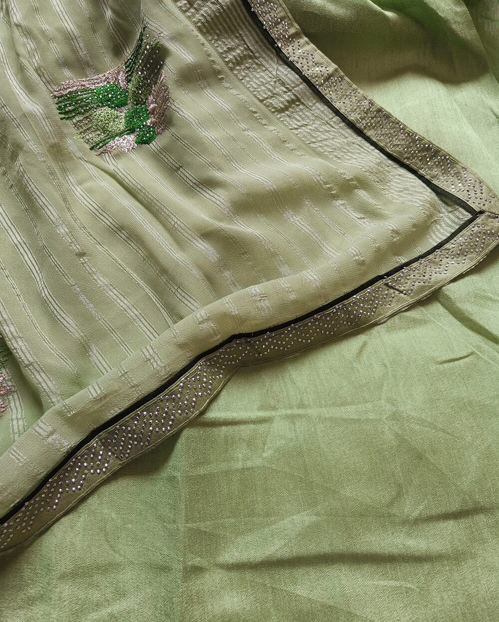 Light weight fancy Georgette Saree in Light Green shade with Swarovski crystal work all over the shoulder and pallu portion along with embroidery floral work pattern. Border throughout the saree and Pallu has Swarovski work .The saree in the skirt portion has embroidery patterns with Swarovski crystal work. The Pallu is beautifully done in a C shape work pattern.