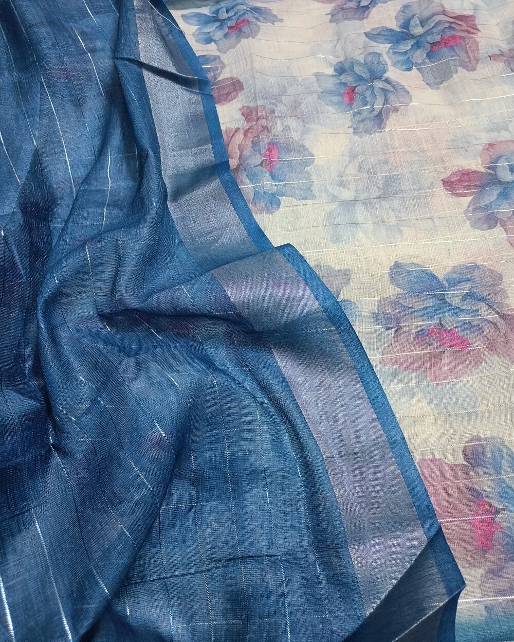 Sky Blue shade Semi Linen saree with silver tissue zari border, this saree comes with digital prints all over with a subtle silver tissue zari border. The pallu is simple with prints.
