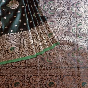 Banarasi Satin silk saree in Dark Bottle Green shade dual tone with floral motifs in light gold zari weaves all over the body. Very unique meenakari work done on the motifs in the base fabric shade. It has a self border with gold work floral motifs. The Pallu is richly woven with intricate Banarasi floral motifs. Meenakari work has been done In the border and pallu that compliments the whole look of the saree. It includes self embossed blouse piece with gold border in same design as the saree.