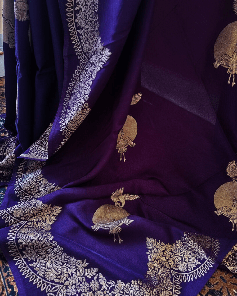 Banarasi Satin Crepe Silk in Royal Violet shade with bird motifs weaves all over the body. Very unique motifs with scallop Design woven in border.It includes plain blouse piece with border in bold and contrast Yellow shade that pairs beautifully the saree and lifts the overall look.