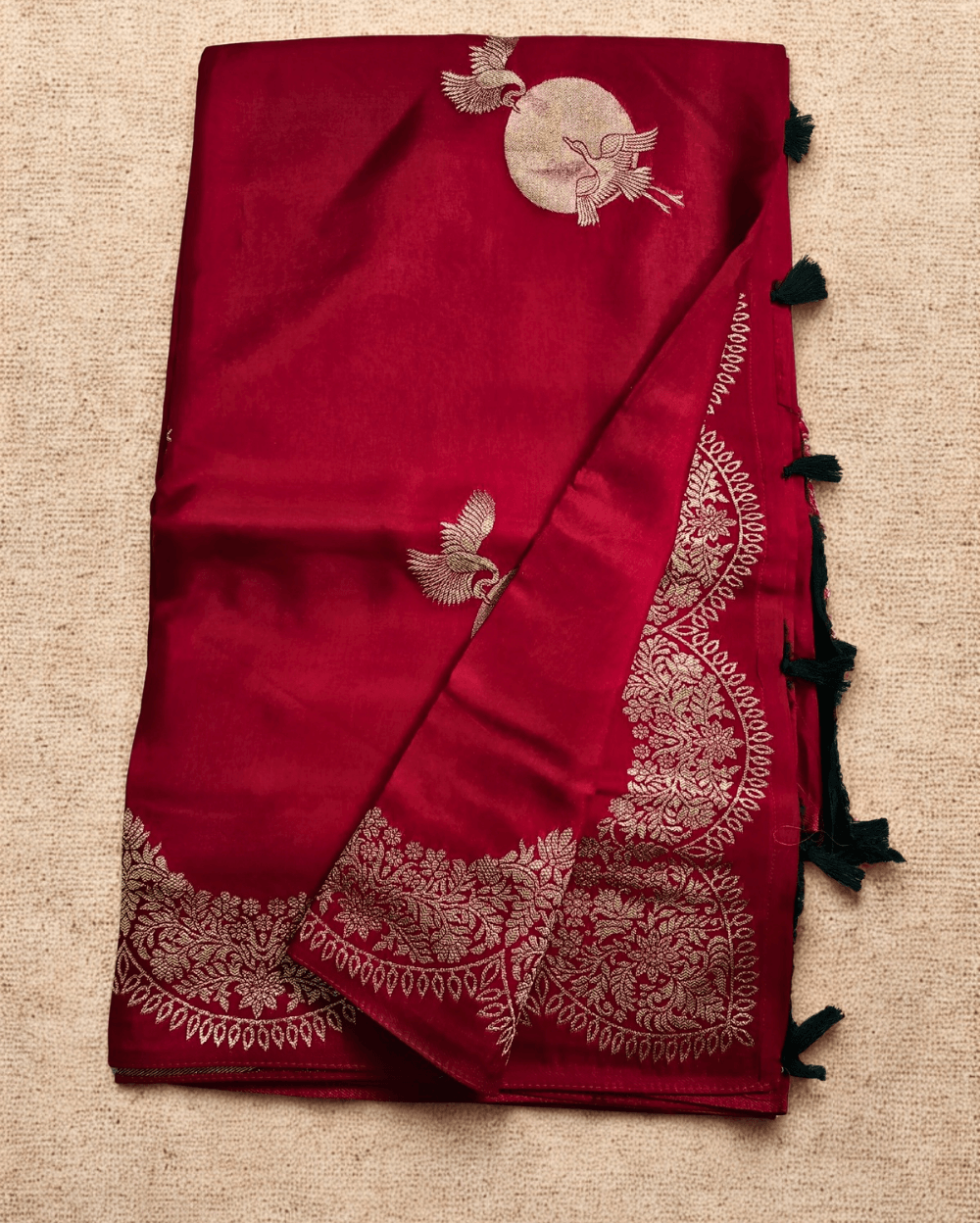 Banarasi Satin Crepe Silk in Deep Red shade with bird motifs weaves all over the body. Very unique motifs with scallop Design woven in border.It includes plain blouse piece with border in bold and contrast Dark Green shade that pairs beautifully the saree and lifts the overall look.
