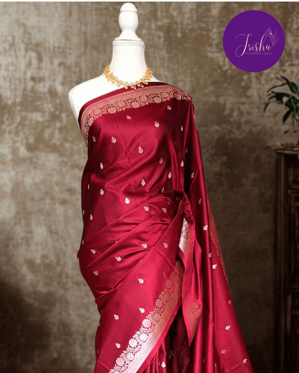 Banarasi Mashru Katan Silk saree in Deep Maroon with small buttis all over the saree. The Rose Gold zari makes the finish very royal and elegant. Saree has a very beautiful traditional border and a very rich pallu that makes the usage of this saree suit any occasion or formal wear. The Pallu is attractively designed and woven with intricate Banarasi floral motifs.