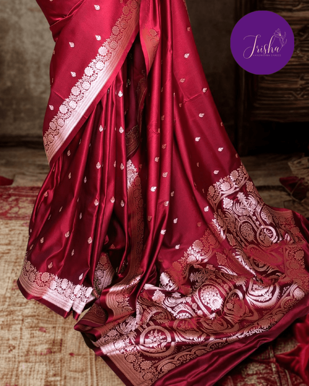 Banarasi Mashru Katan Silk saree in Deep Maroon with small buttis all over the saree. The Rose Gold zari makes the finish very royal and elegant. Saree has a very beautiful traditional border and a very rich pallu that makes the usage of this saree suit any occasion or formal wear. The Pallu is attractively designed and woven with intricate Banarasi floral motifs.