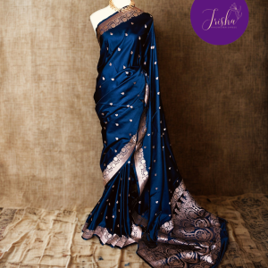 Banarasi Mashru Katan Silk saree in Blue shade with small buttis all over the saree. The Rose Gold zari makes the finish very royal and elegant. Saree has a very beautiful traditional border and a very rich pallu that makes the usage of this saree suit any occasion or formal wear. The Pallu is attractively designed and woven with intricate Banarasi floral motifs.