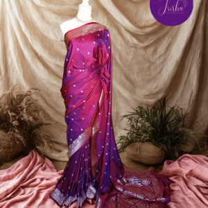 Banarasi Mashru Katan Silk saree in Pink Purple dual tone shade with small buttis all over the saree. The Rose Gold zari makes the finish very royal and elegant. Saree has a very beautiful traditional border and a very rich pallu that makes the usage of this saree suit any occasion or formal wear. The Pallu is attractively designed and woven with intricate Banarasi floral motifs.