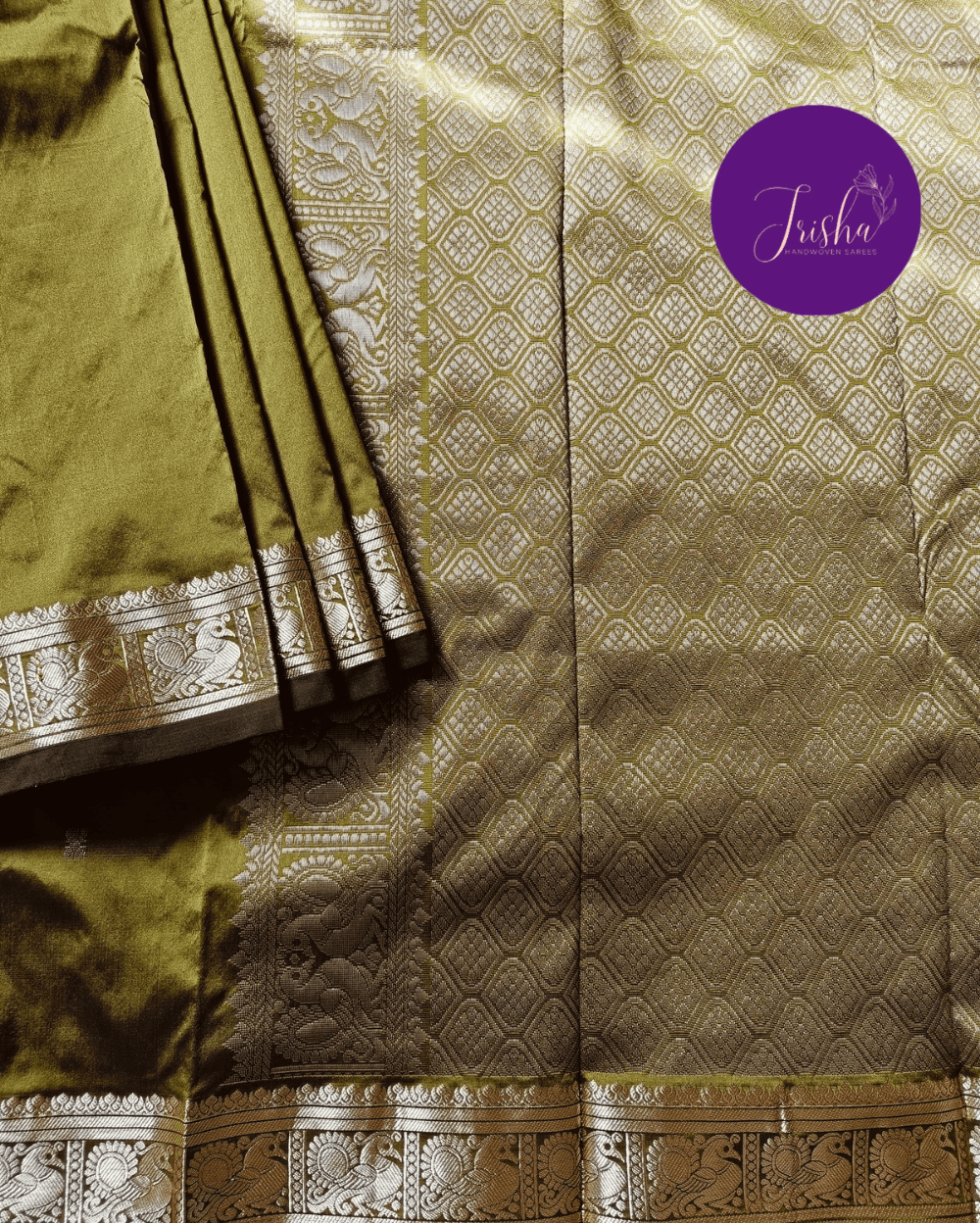 Kanchipuram / Kanjivaram Silk Saree with Gold Zari Border on both sides with traditional Kanchipuram Peacock motifs. Light Green saree with Self Border and Pallu. Traditional Peacock motifs in the border with floral motifs all over pallu. Body of the saree has small floral buttas in two different geometric patterns.